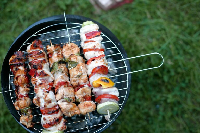 Knackiges buntes Grillgemüse auf Holzkohlegrill mit Grillrost und Grillzange