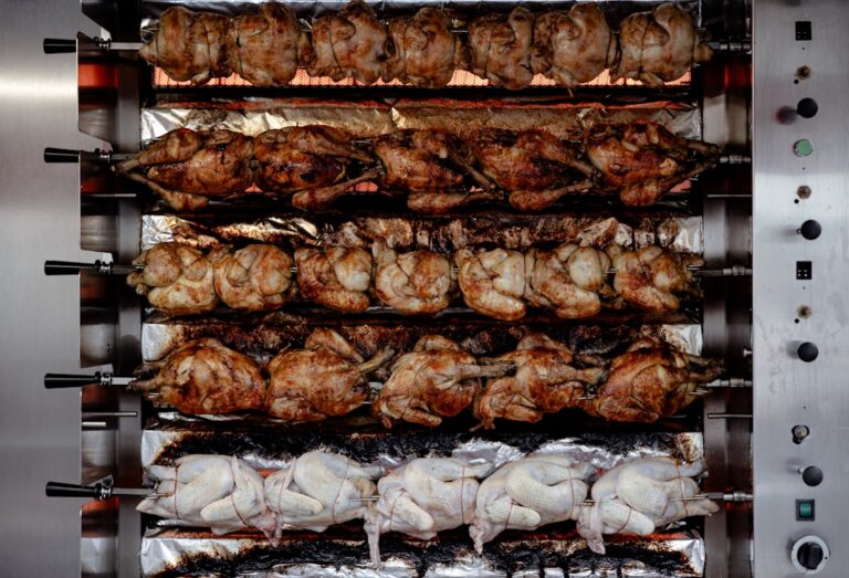 Moderne Hähnchen Grill mit Drehspieß und knusprigem Grillhähnchen auf Holzkohlegrill