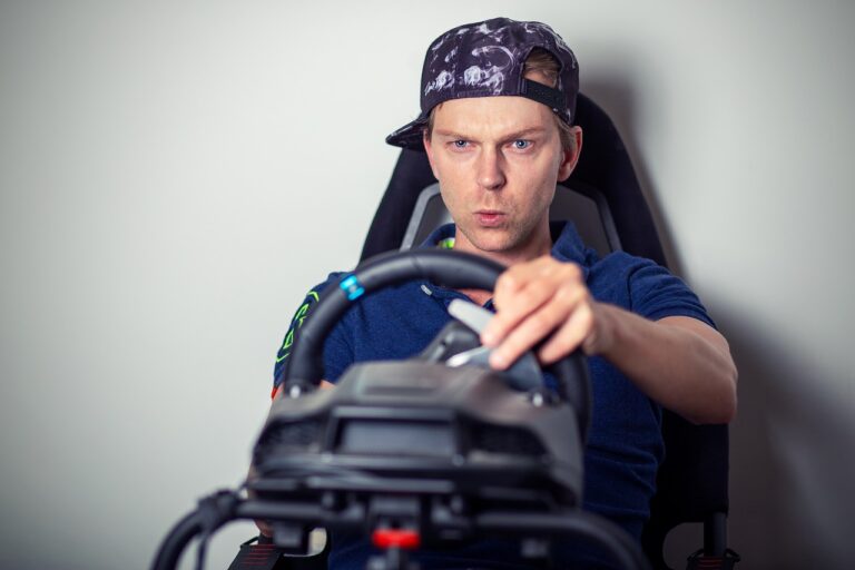 Simracing Setup mit Gaming-Equipment und entspanntem Grillplatz im Hintergrund