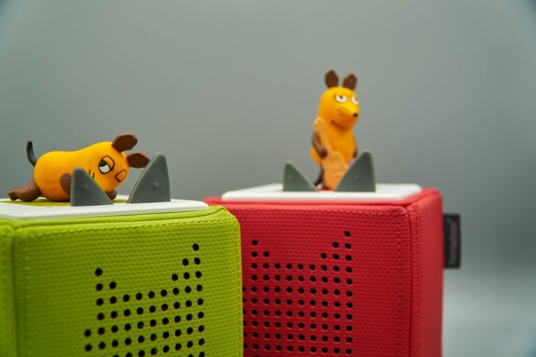 Kind spielt mit bunter Toniebox im Garten beim Familien-Grillabend